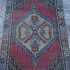 Close-up of the red Turkish small vintage rug showing traditional details, hand-knotted weave, wool and cotton and low pile.