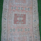 Close-up of the pale orange Turkish small wool rug showing neutral details, hand-knotted weave, wool and low pile.