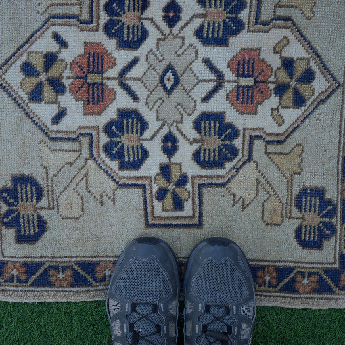 Close-up of the blue sqaure turkish rug showing neutral details, hand-knotted weave, wool and cotton and low pile.