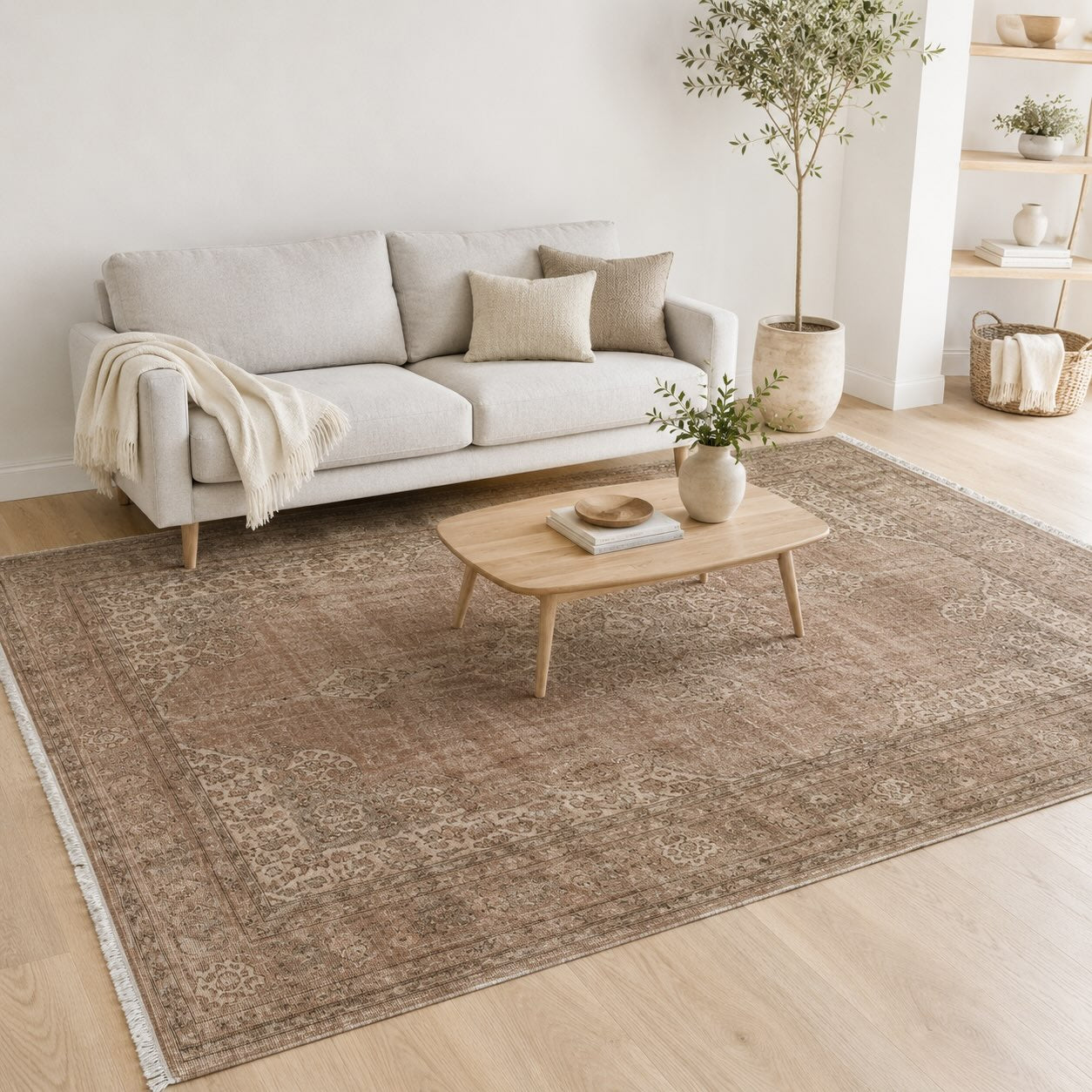 Taupe and brown vintage medallion rug grounding a light gray sofa in a Scandinavian-style living room