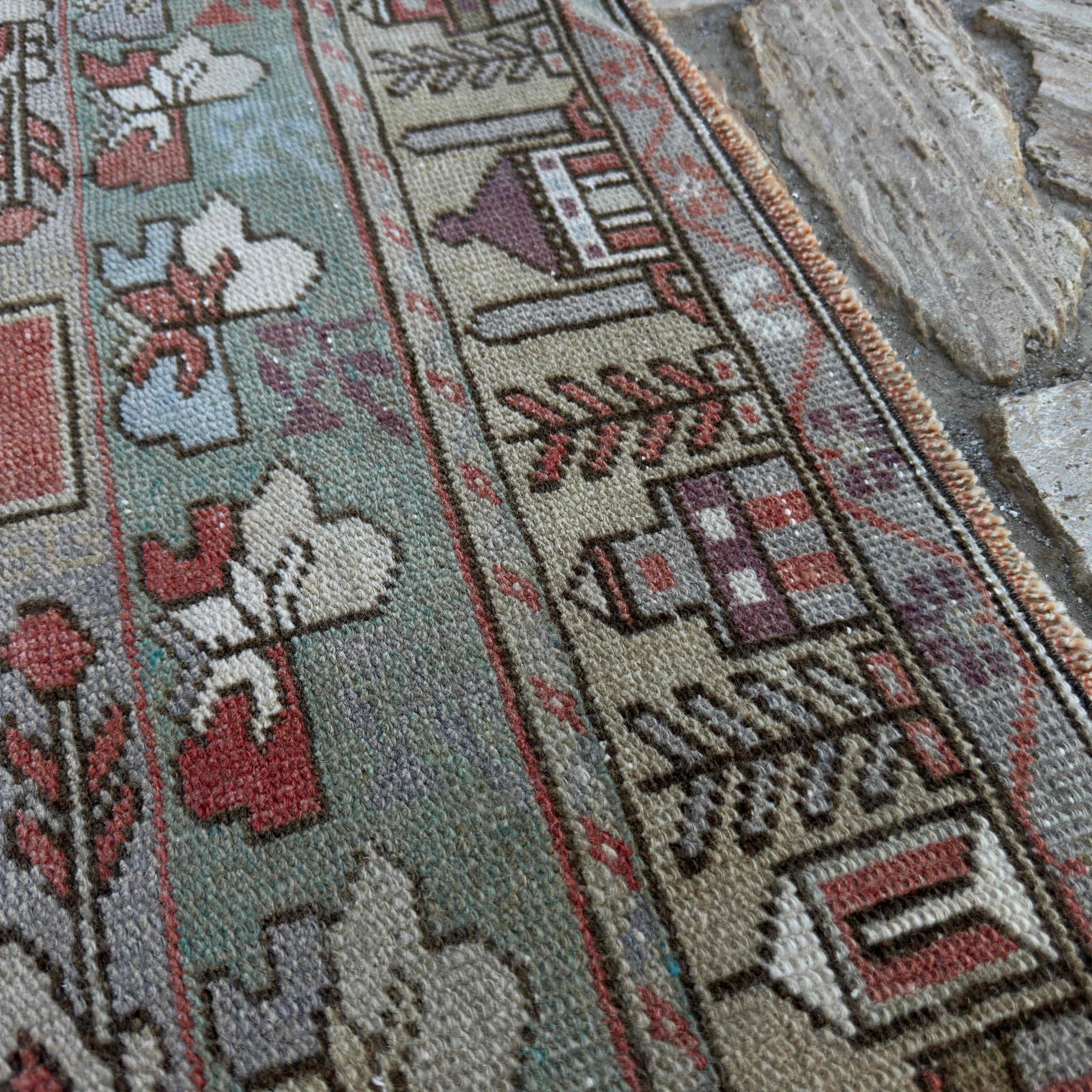Close-up of the red Turkish traditional rug showing traditional details, hand-knotted weave, wool and cotton and low pile.