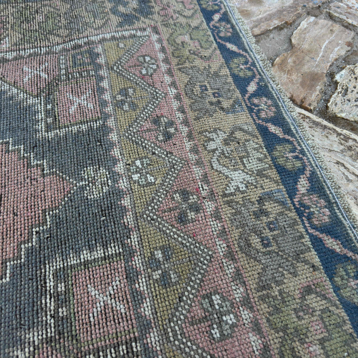 Close-up of the pink traditional turkish rug, hand-knotted weave, wool and cotton and low pile.