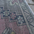 Close-up of the pink traditional turkish rug showing traditional details, hand-knotted weave, wool and cotton and low pile.