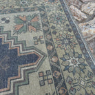 Close-up of the orange Turkish traditional vintage rug showing traditional details, hand-knotted weave, wool and cotton and low pile.