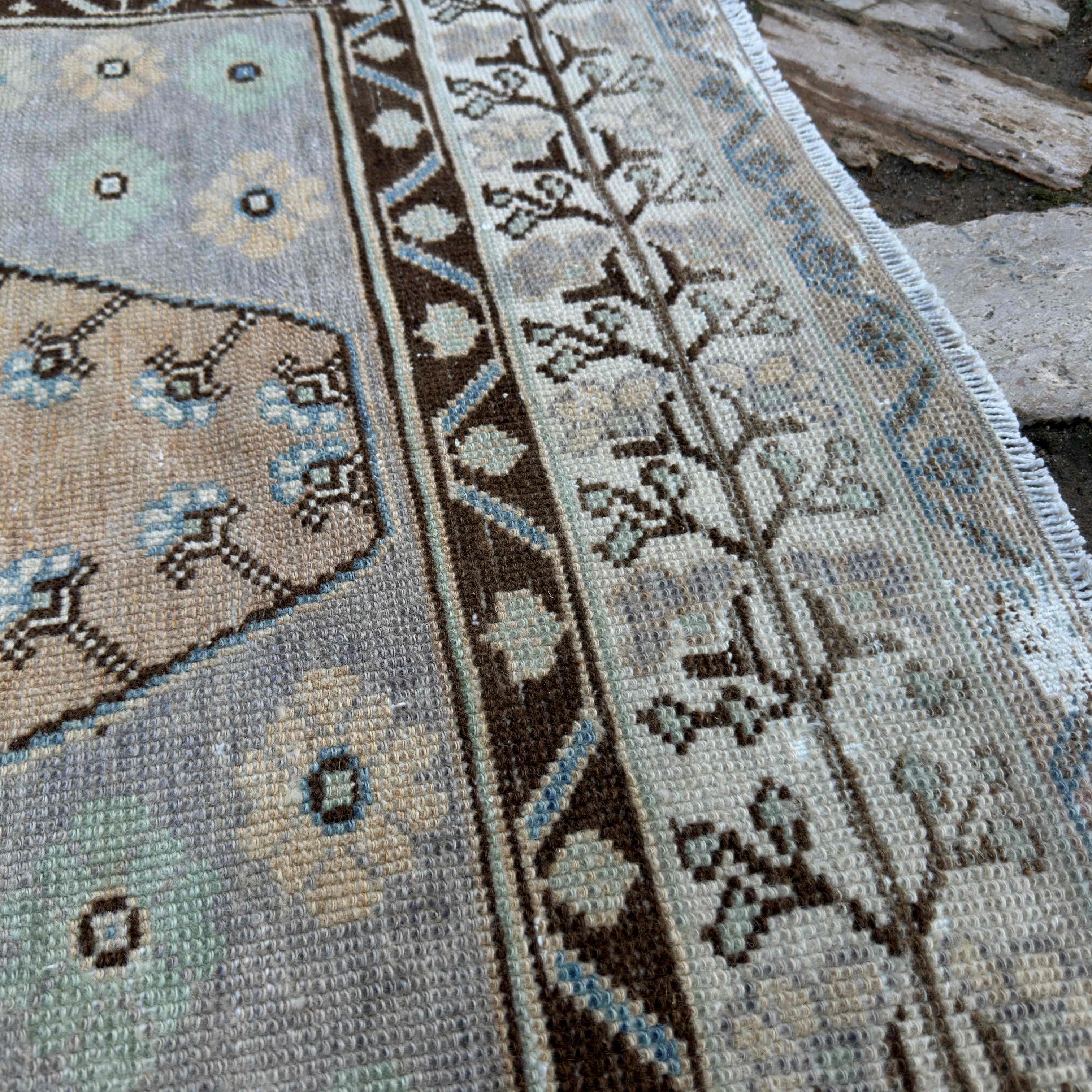 Close-up of the pale orange turkish area rug showing traditional details, hand-knotted weave, wool and cotton and low pile.