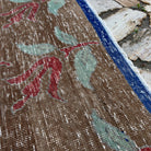Close-up of the pale brown turkish floral rug showing floral details, hand-knotted weave, wool and cotton and low pile.