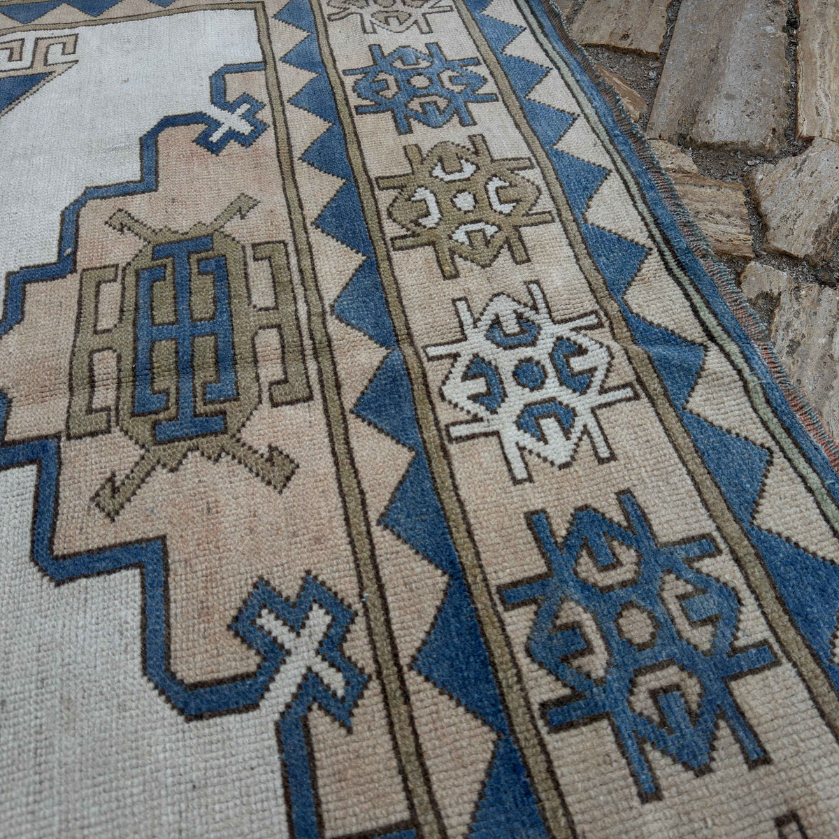Close-up of the pale blue turkish geometric carpet showing traditional details, hand-knotted weave, wool and cotton and low pile.