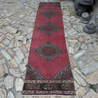 Red 3' x 11' turkish geometric runner rug in wool and cotton, shown on the floor.