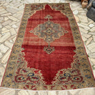 Red 5' x 9' turkish medallion rug in wool and cotton, shown on the floor.