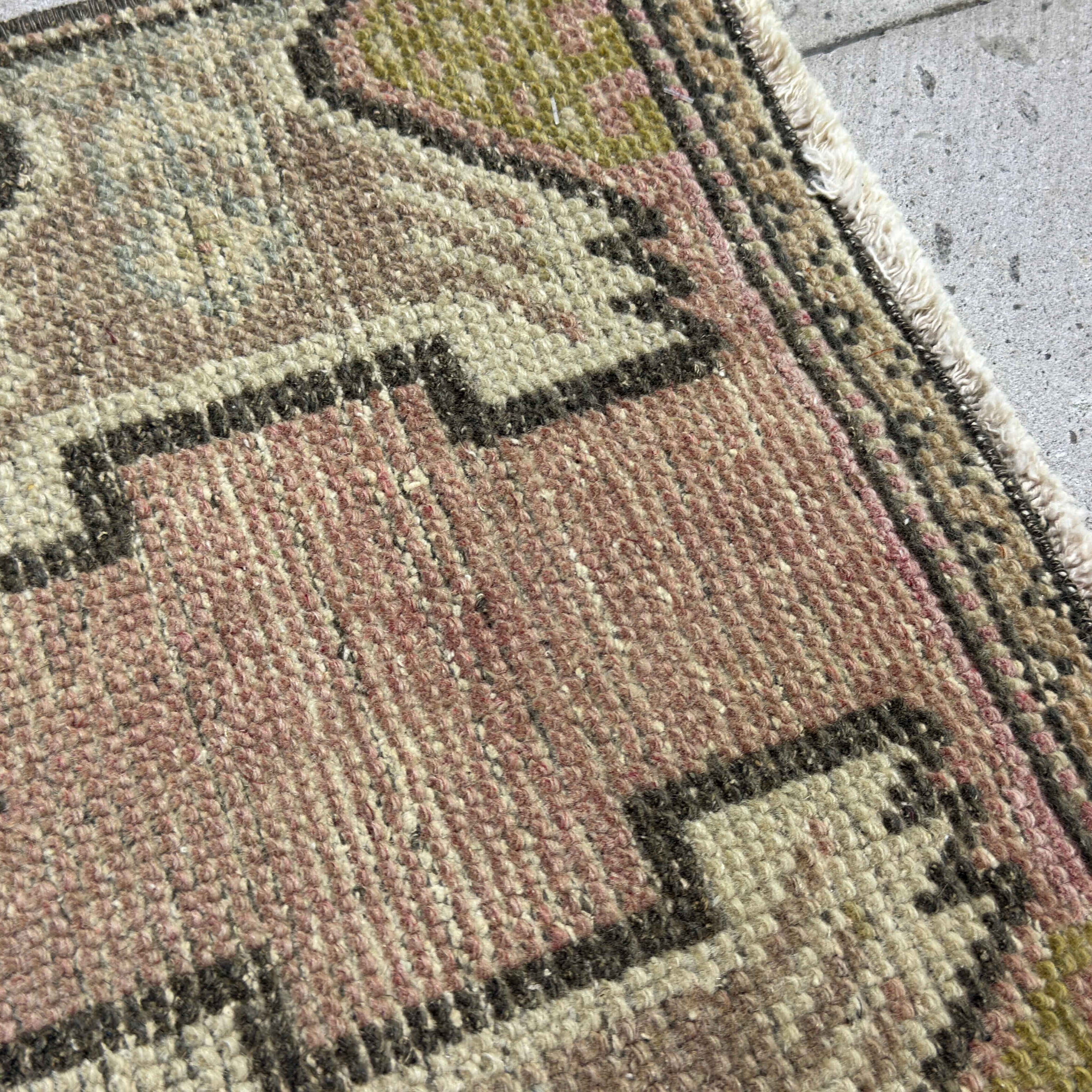 Close-up of the pink turkish mini rug showing traditional details, hand-knotted weave, wool and cotton and low pile.