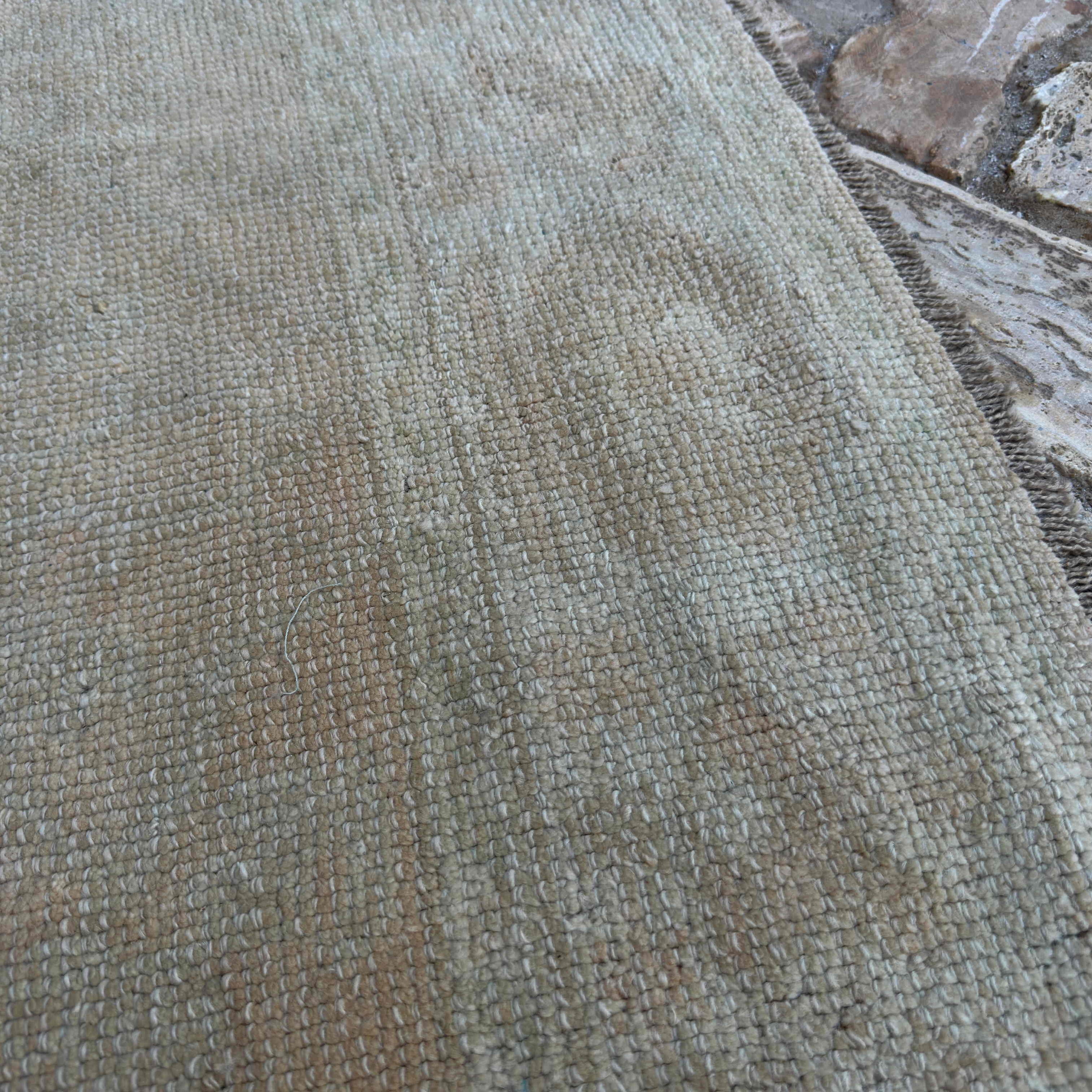Close-up of the beige turkish oushak rug showing neutral details, hand-knotted weave, wool and cotton and low pile.