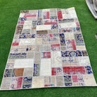 Red 4' x 5' turkish patchwork rug in wool and cotton, shown on the floor.