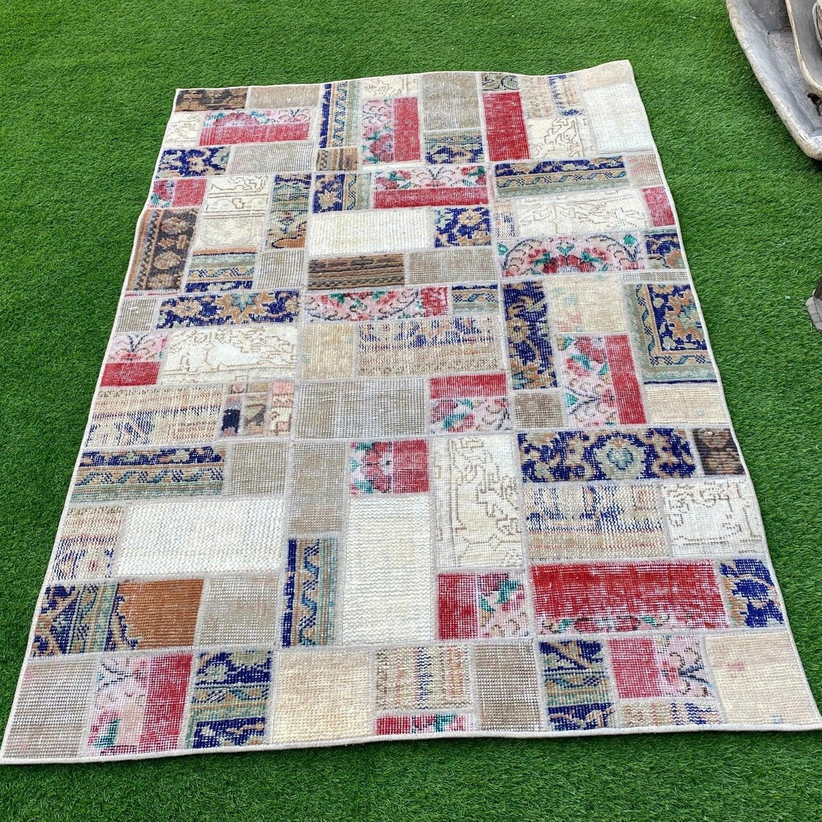 Red 4' x 5' turkish patchwork rug in wool and cotton, shown on the floor.