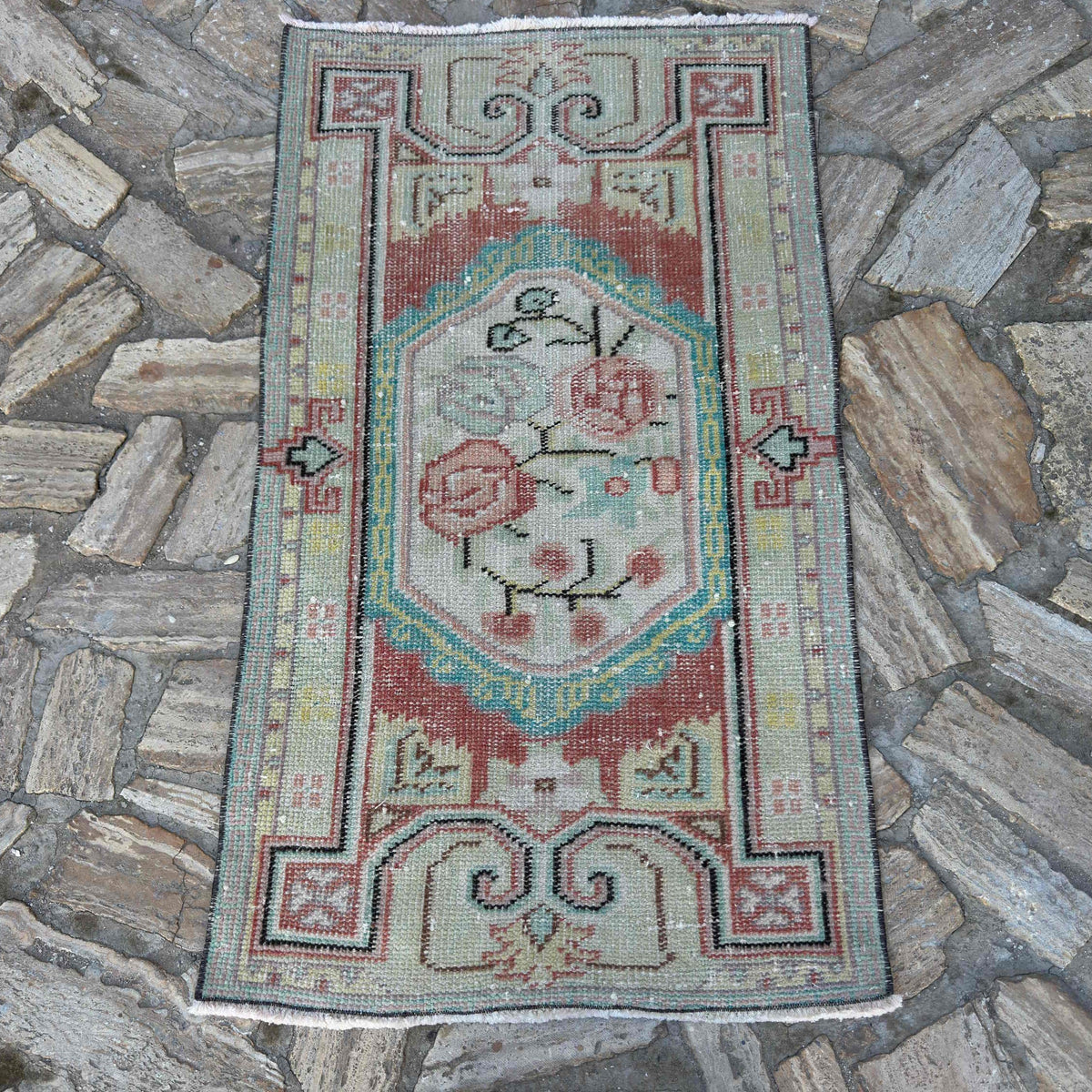 Red 2' x 4' turkish rug in wool and cotton, shown on the floor.