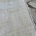 Close-up of the beige turkish rug showing neutral details, hand-knotted weave, wool and cotton and low pile.