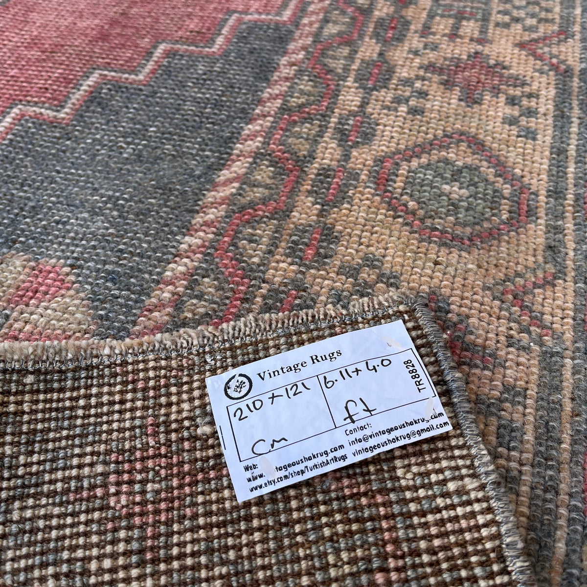 Close-up of the pale red turkish rug showing traditional details, hand-knotted weave, wool and cotton and low pile.