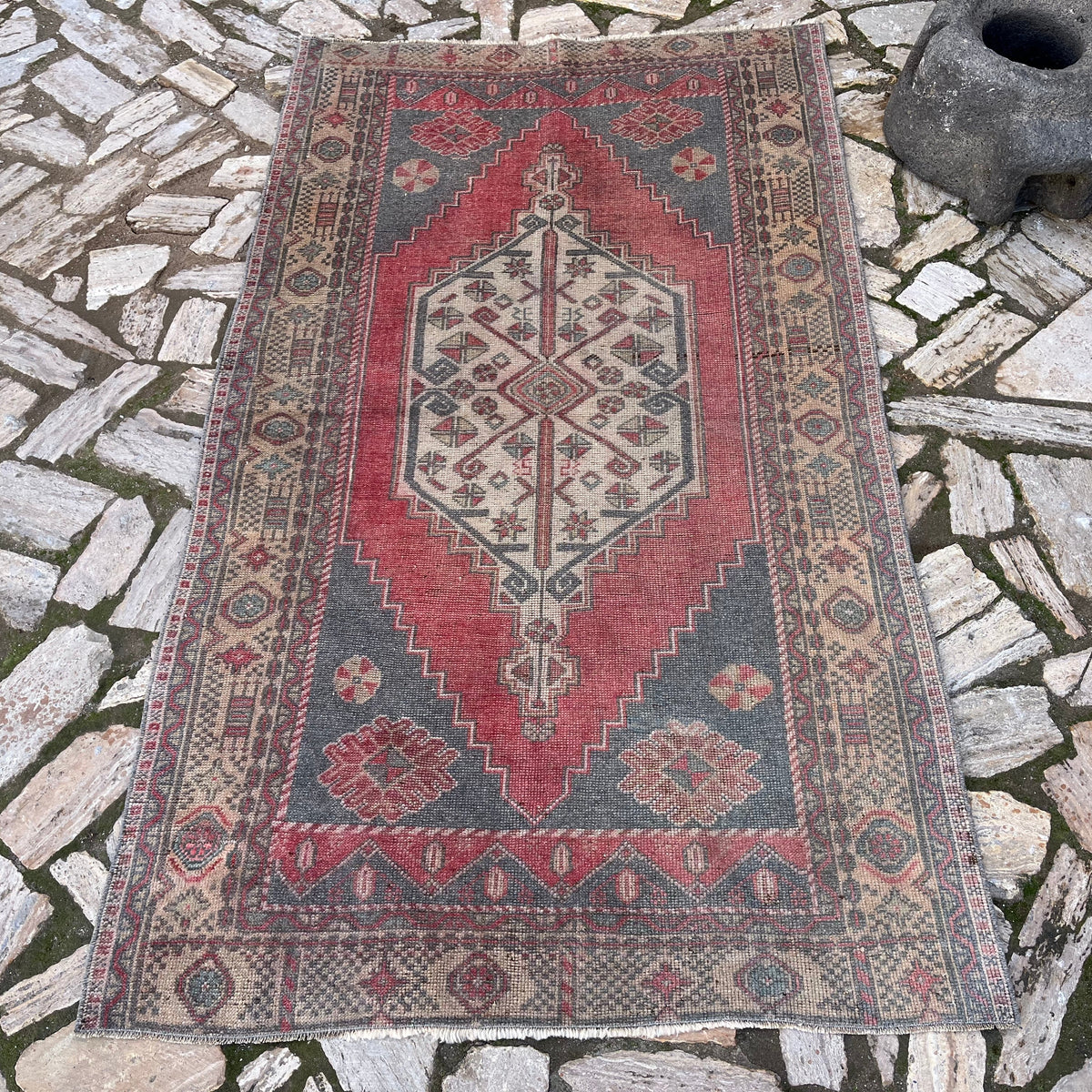 Pale Red 4' x 7' turkish rug in wool and cotton, shown on the floor.