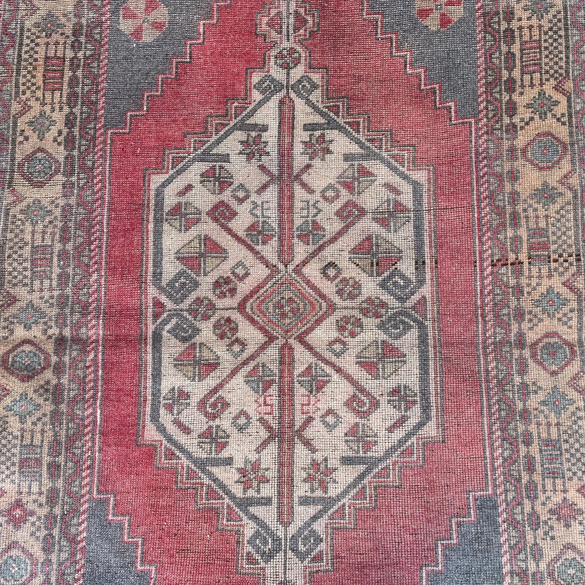1970s pale red turkish rug with traditional design, hand-knotted weave and low pile.