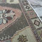 Close-up of the pale red turkish rug showing traditional details, hand-knotted weave, wool and cotton and low pile.