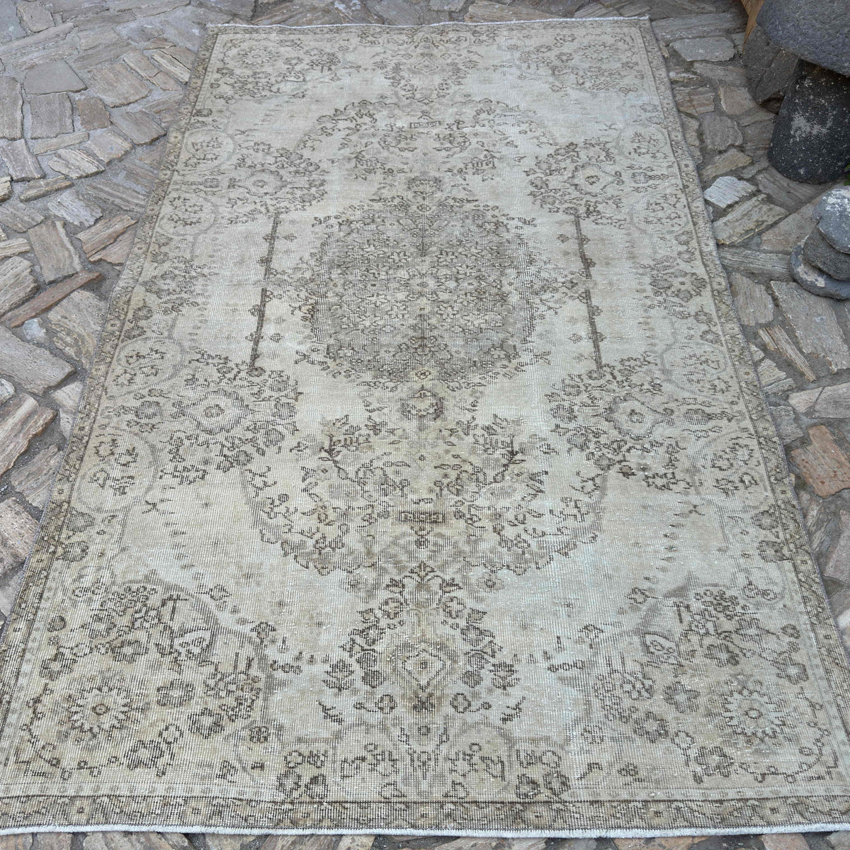 Beige 5' x 9' turkish rug in wool and cotton, shown on the floor.