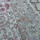 Close-up of the red turkish rug showing medallion details, hand-knotted weave, wool and cotton and low pile.