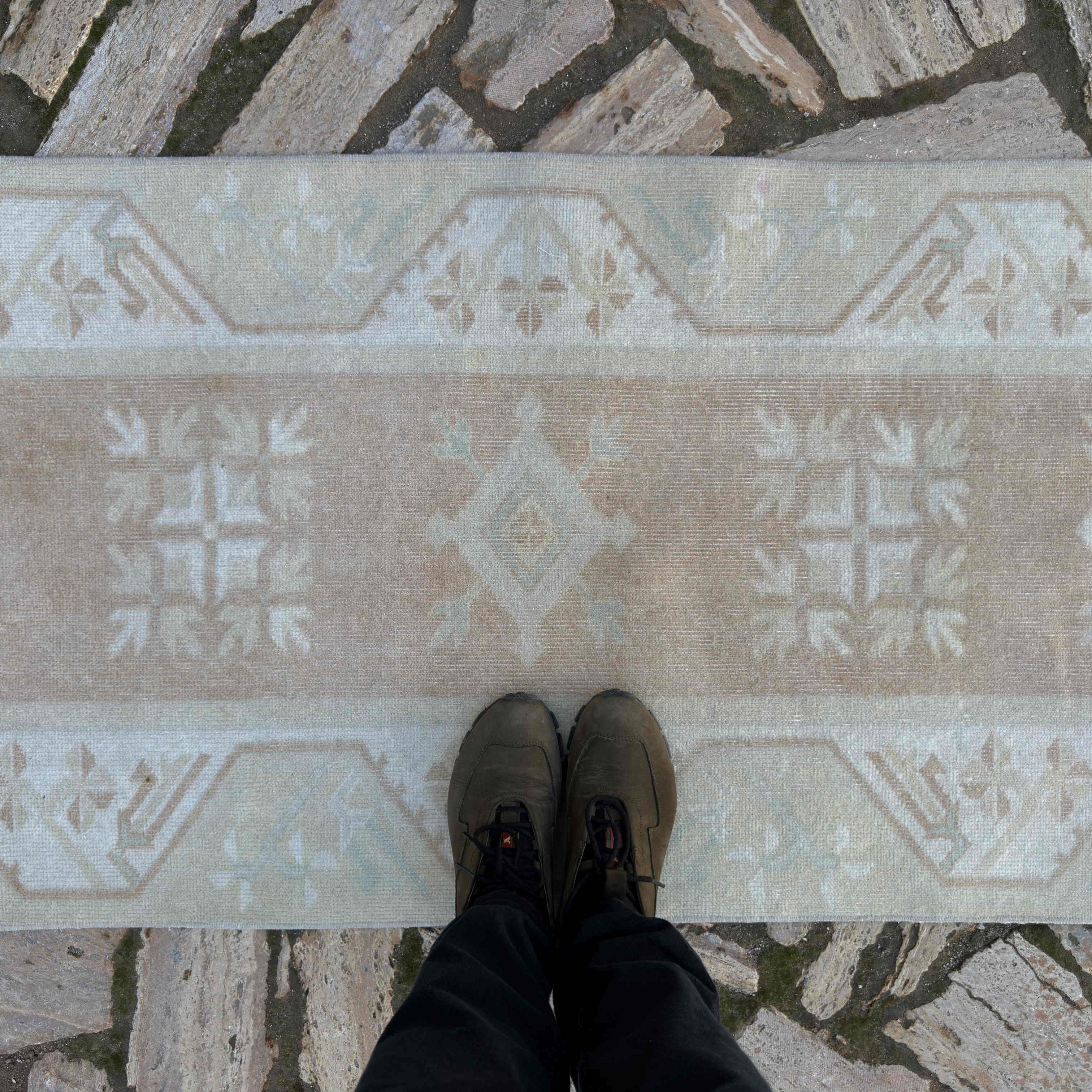 1970s beige turkish runner rug with neutral design, hand-knotted weave and low pile.