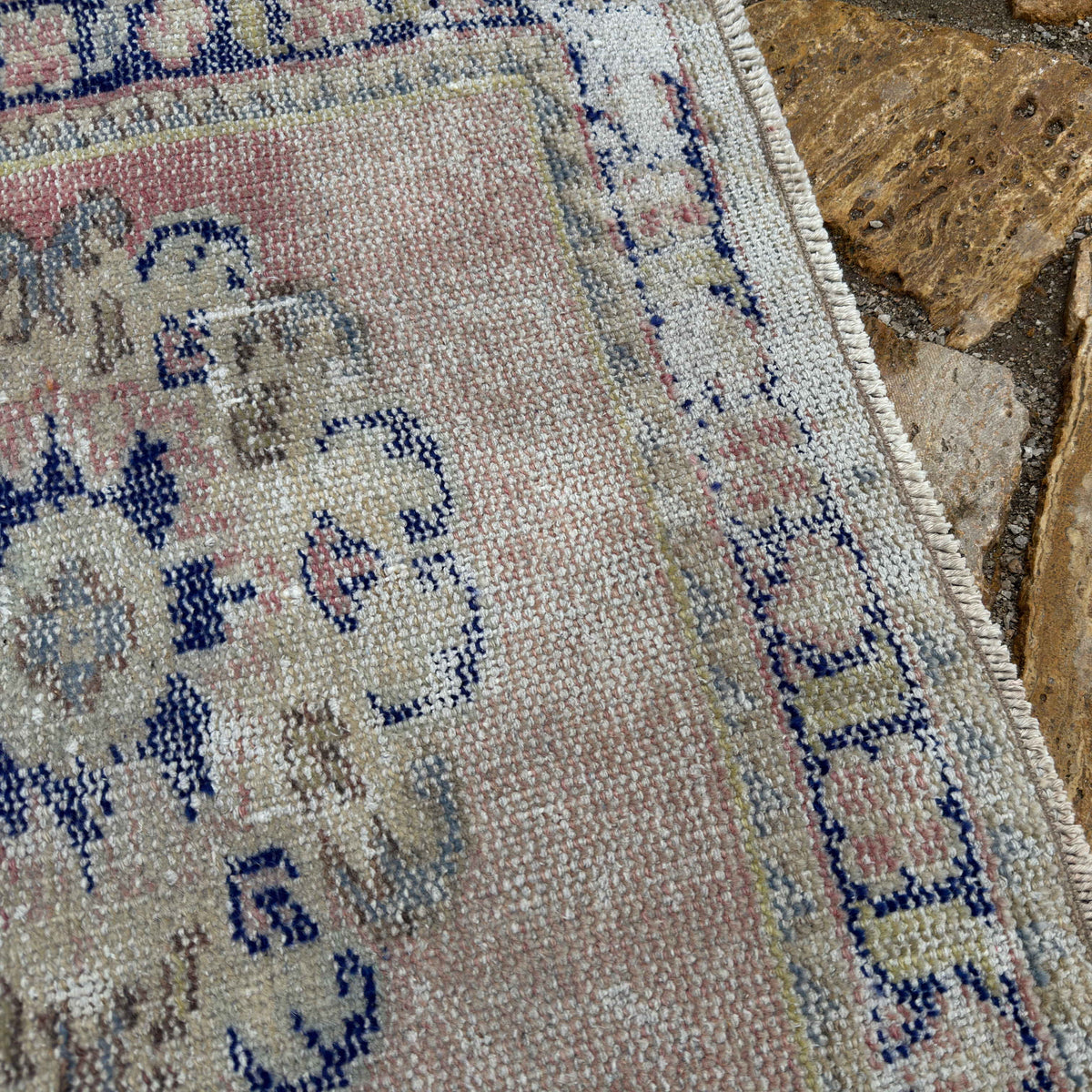 Close-up of the pale pink turkish runner rug showing medallion details, hand-knotted weave, wool and cotton and low pile.