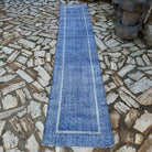 Blue 2' x 12' turkish runner rug in wool and cotton, shown on the floor.