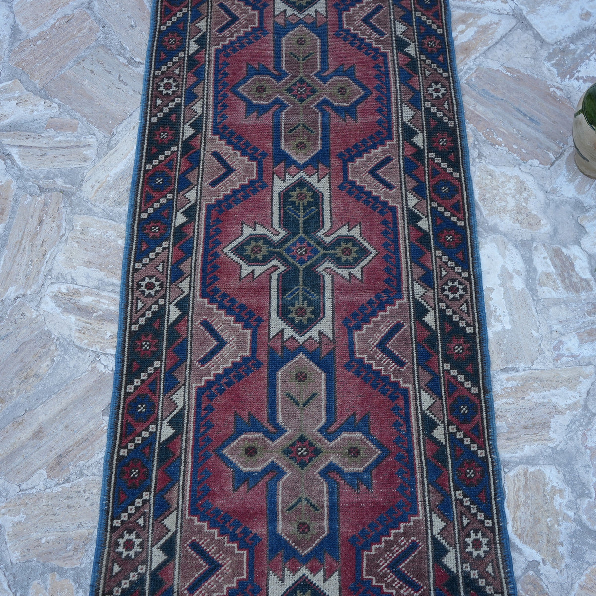 Close-up of the red turkish runner rug showing traditional details, hand-knotted weave, wool and low pile.