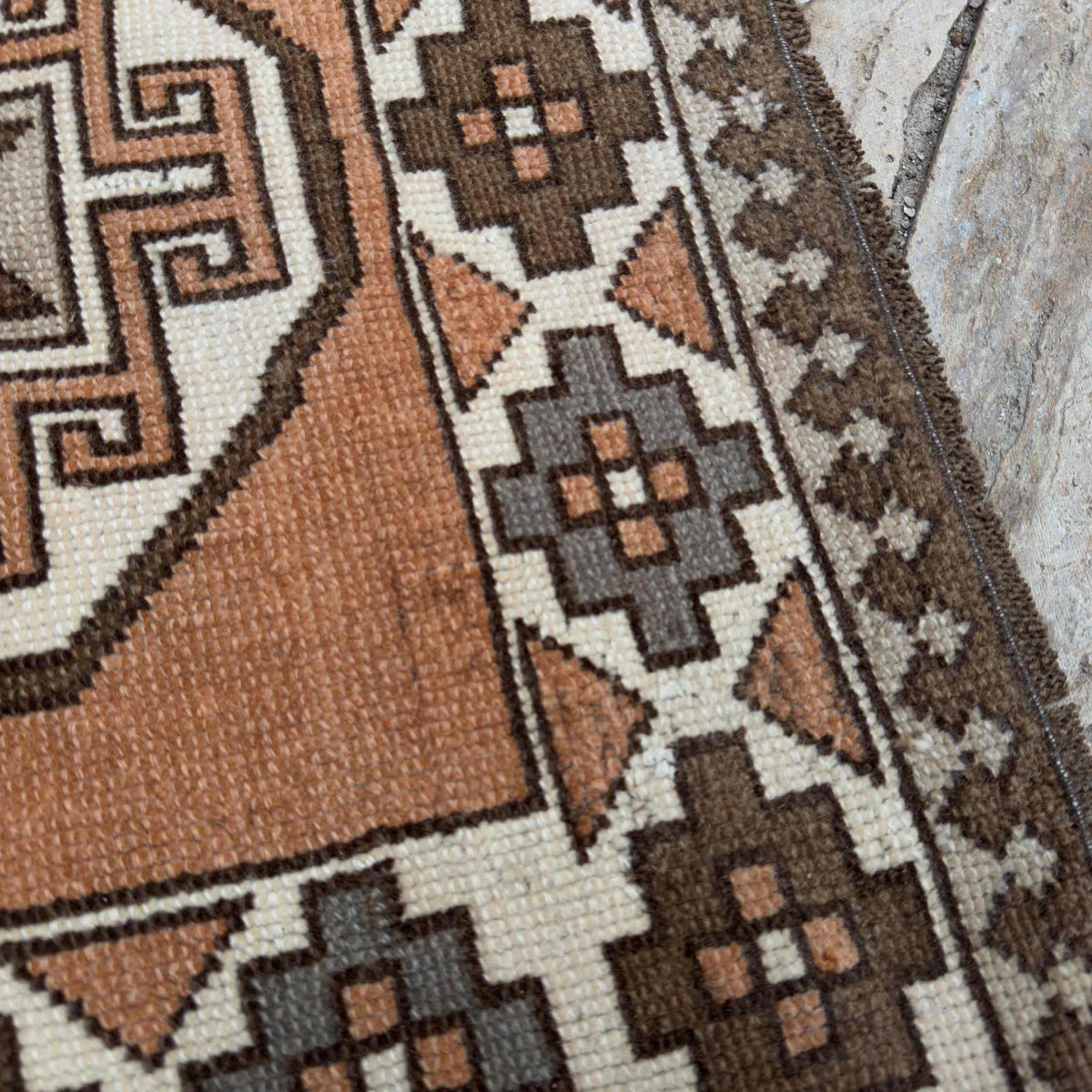 Close-up of the pale orange turkish runner rug showing traditional details, hand-knotted weave, wool and cotton and low pile.