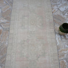 Close-up of the pale pink turkish runner rug showing traditional details, hand-knotted weave, wool and cotton and low pile.