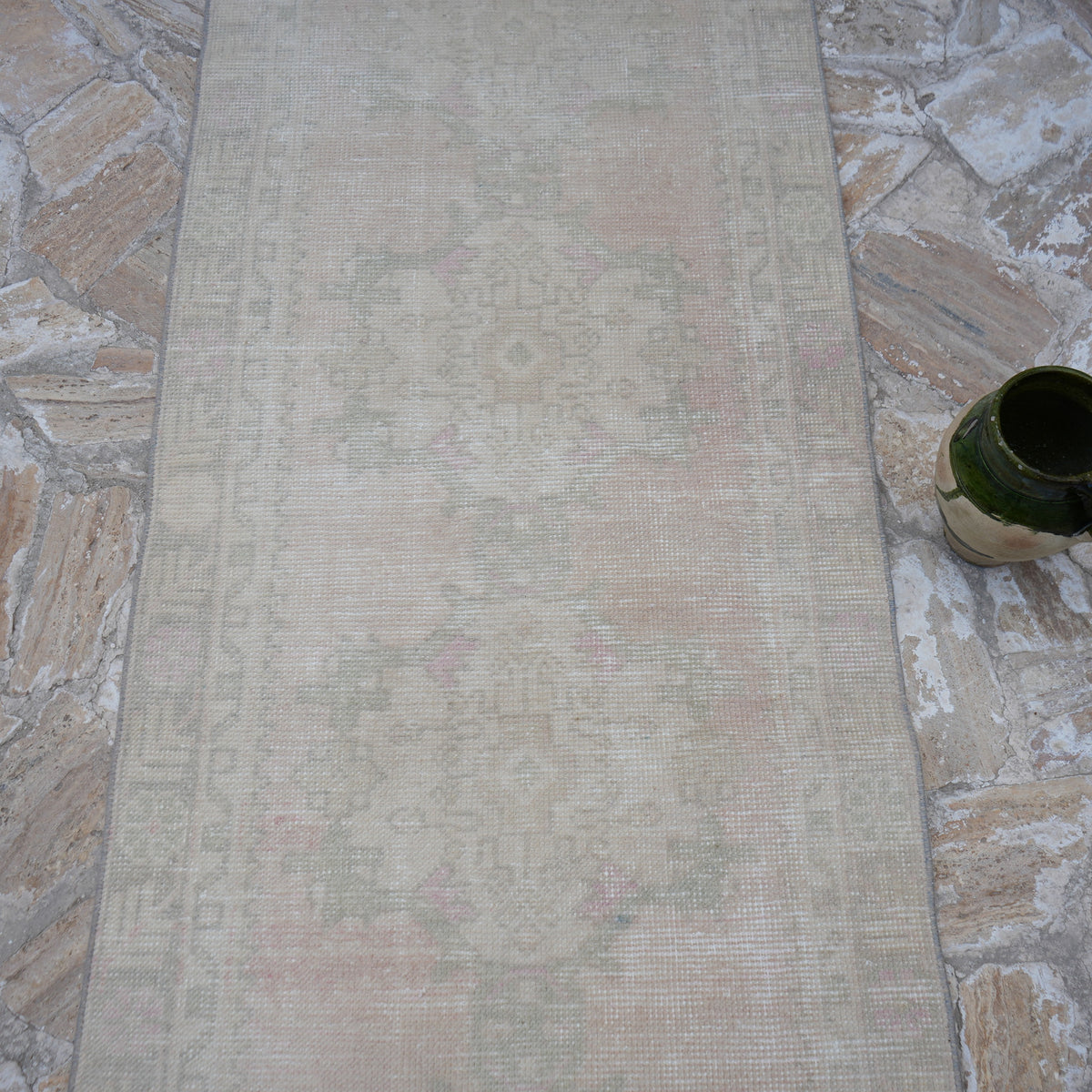 Close-up of the pale pink turkish runner rug showing traditional details, hand-knotted weave, wool and cotton and low pile.