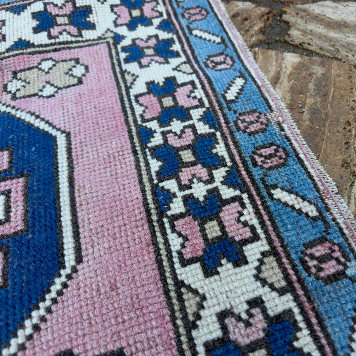 Close-up of the pink turkish runner rug showing traditional details, hand-knotted weave, wool and cotton and low pile.