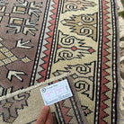Close-up of the beige turkish runner rug showing geometric details, hand-knotted weave, wool and cotton and low pile.
