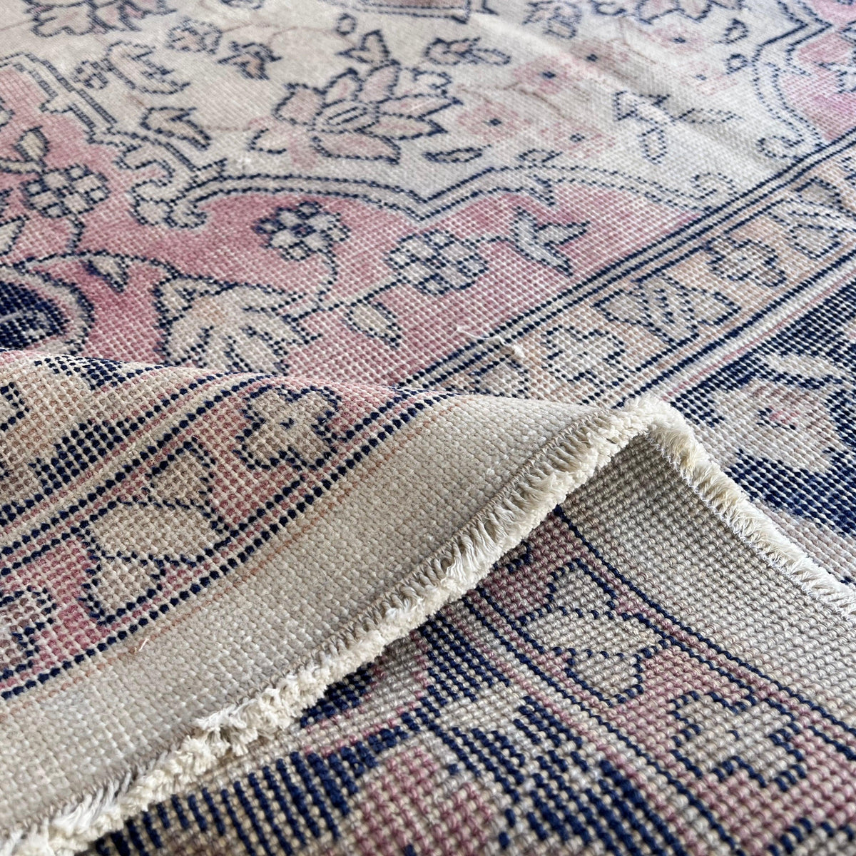 Close-up of the blue turkish traditional rug showing medallion details, hand-knotted weave, wool and cotton and low pile.