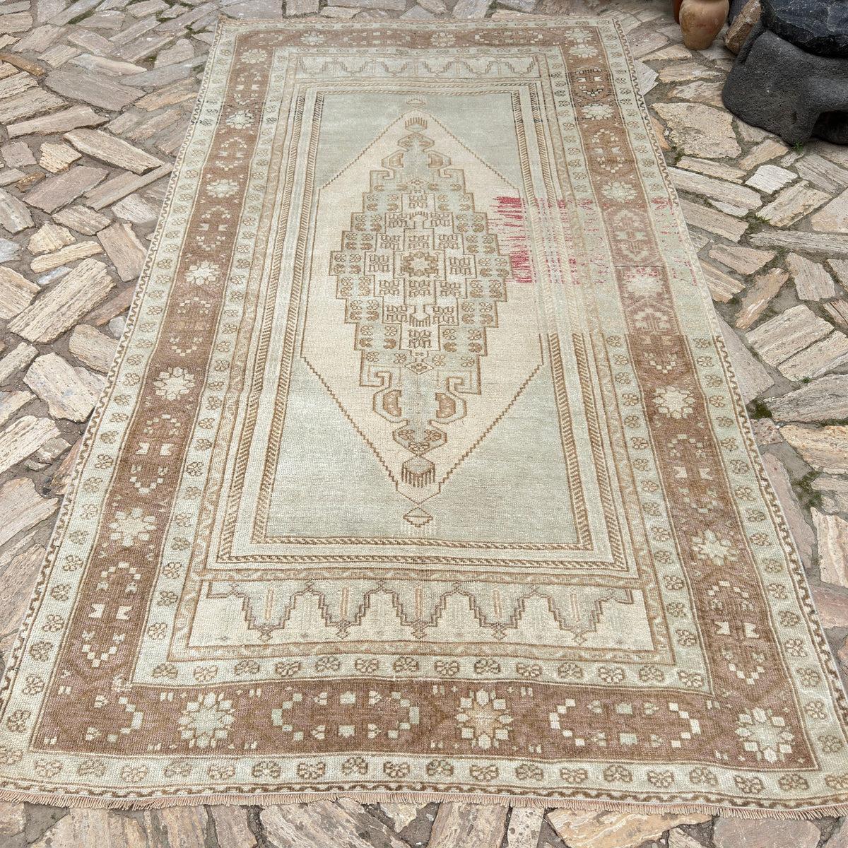 Brown 5' x 9' turkish wool rug in wool and cotton, shown on the floor.