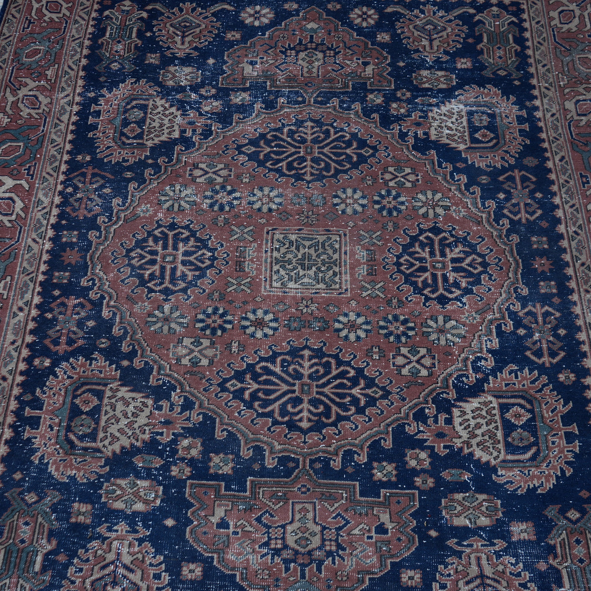 Close-up of the blue Turkish unique vintage oushak rug showing traditional details, hand-knotted weave, wool and cotton and low pile.