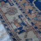 Blue 5' x 9' Turkish unique vintage rug in wool and cotton, shown on the floor.