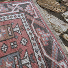 Close-up of the pale red vintage Turkish anatolia rug showing traditional details, hand-knotted weave, wool and cotton and low pile.