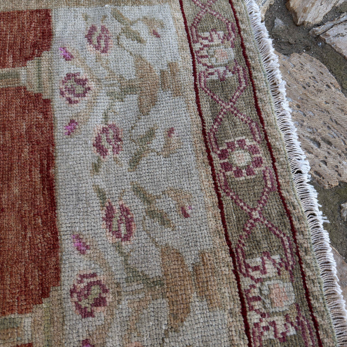 Close-up of the red vintage Turkish anatolia rug showing traditional details, hand-knotted weave, wool and cotton and low pile.