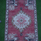 Close-up of the red vintage Turkish anatolian rug showing traditional details, hand-knotted weave, wool and cotton and low pile.