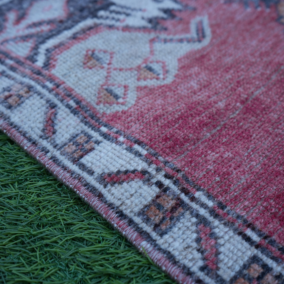 Red 2' x 3' vintage Turkish anatolian rug in wool and cotton, shown on the floor.