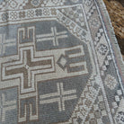 Close-up of the pale blue vintage Turkish anatolian rug showing neutral details, hand-knotted weave, wool and cotton and low pile.