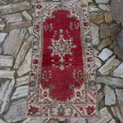 Red 2' x 5' vintage Turkish anatolian rug in wool and cotton, shown on the floor.