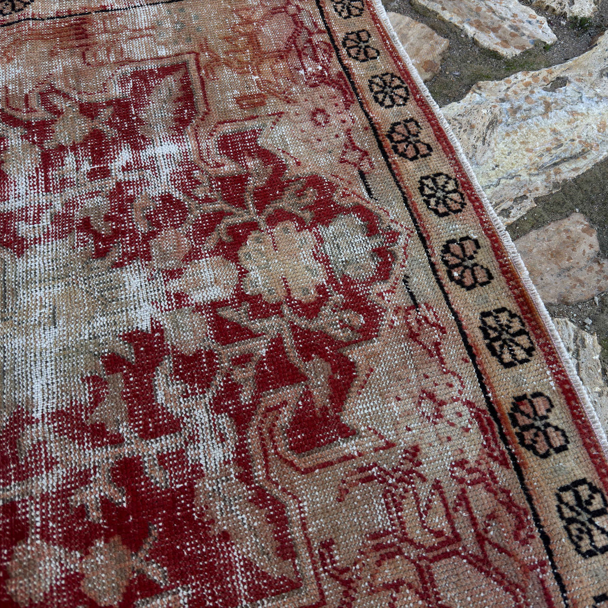 Close-up of the red vintage Turkish anatolian rug showing medallion details, hand-knotted weave, wool and cotton and low pile.