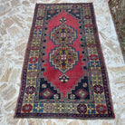 Red 4' x 7' vintage Turkish anatolian rug in wool and cotton, shown on the floor.