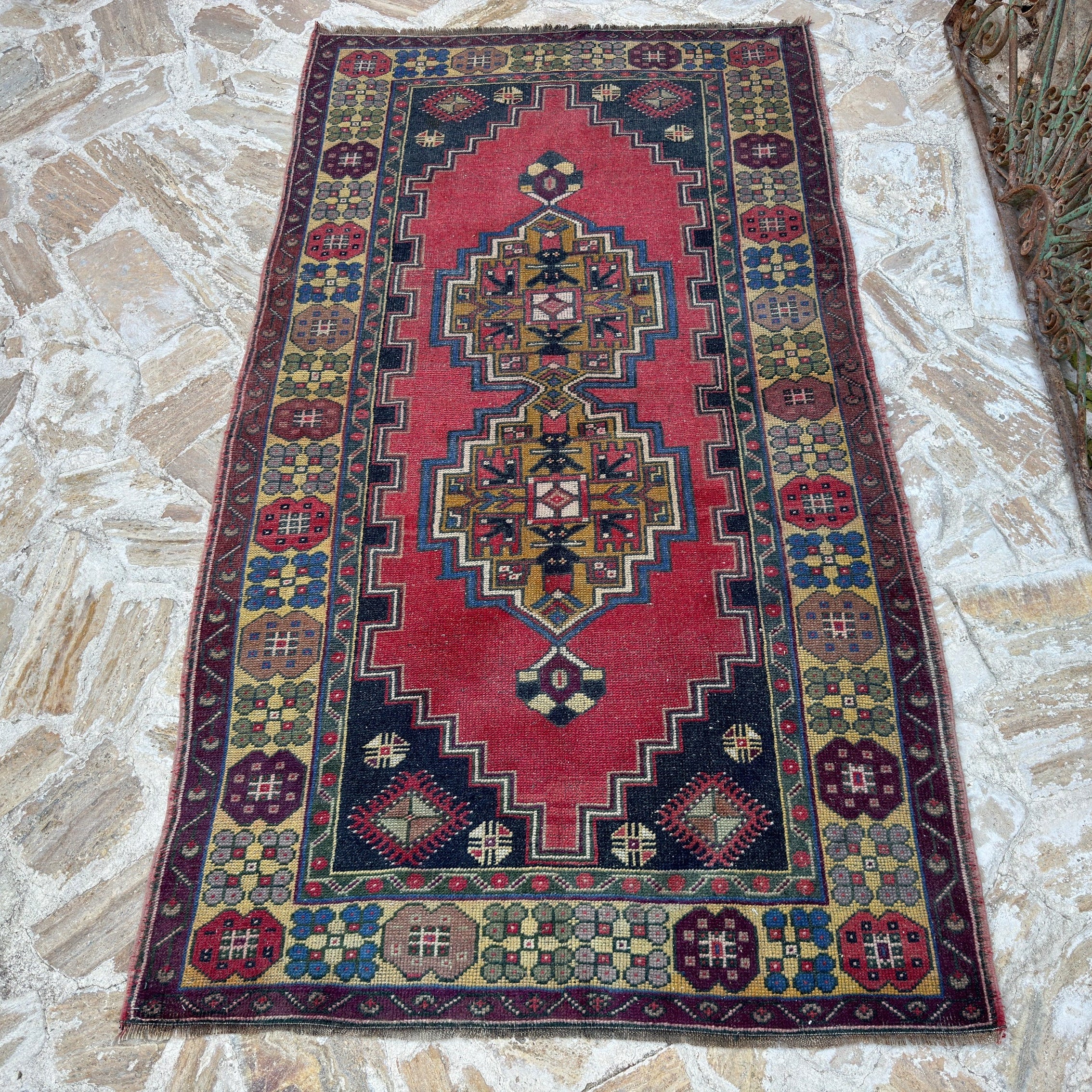 Red 4' x 7' vintage Turkish anatolian rug in wool and cotton, shown on the floor.