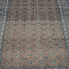 Close-up of the pale orange vintage Turkish anatolian rug showing geometric details, hand-knotted weave, wool and cotton and low pile.
