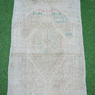 Close-up of the beige vintage Turkish area rug showing neutral details, hand-knotted weave, wool and cotton and low pile.