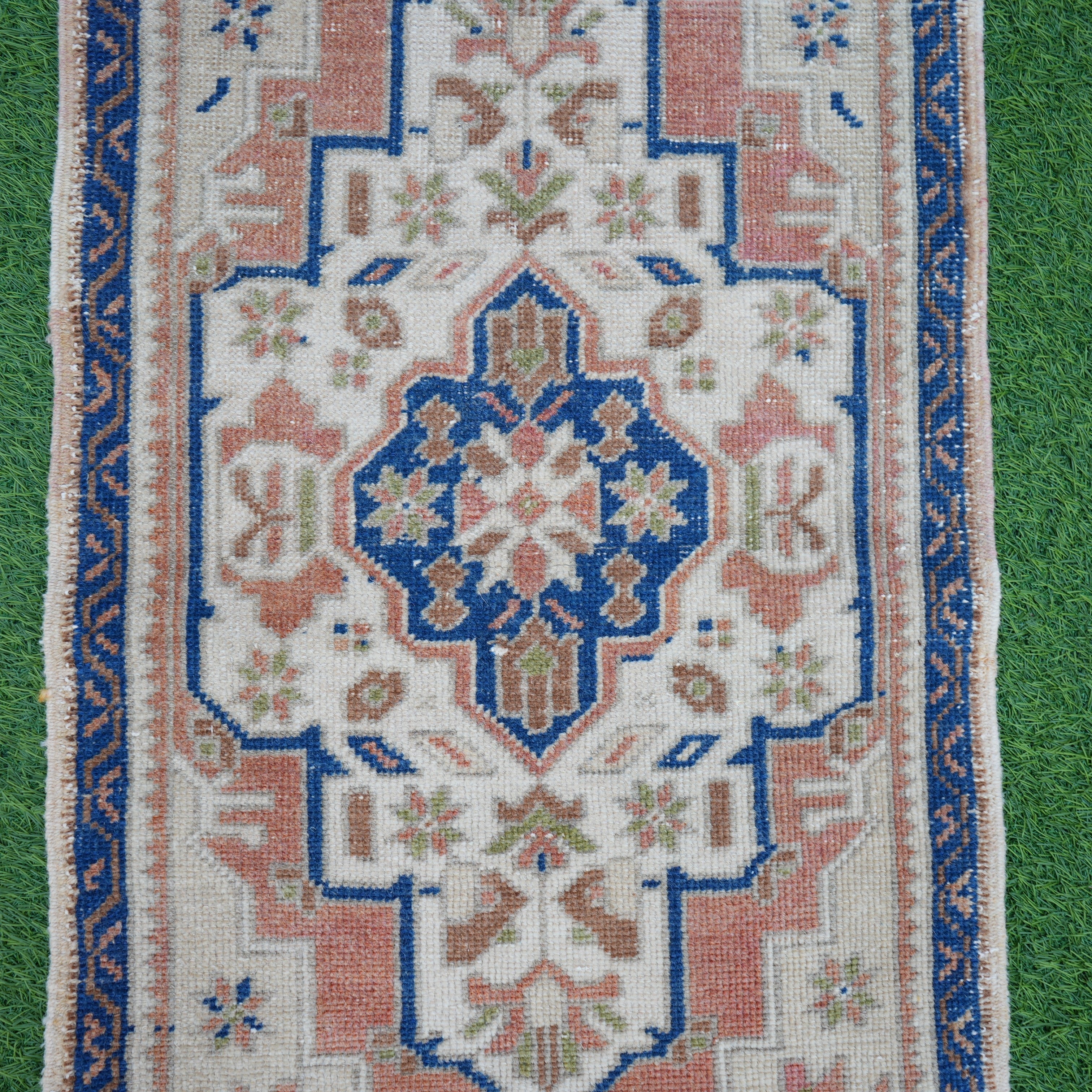 Close-up of the blue vintage Turkish area rug showing traditional details, hand-knotted weave, wool and cotton and low pile.